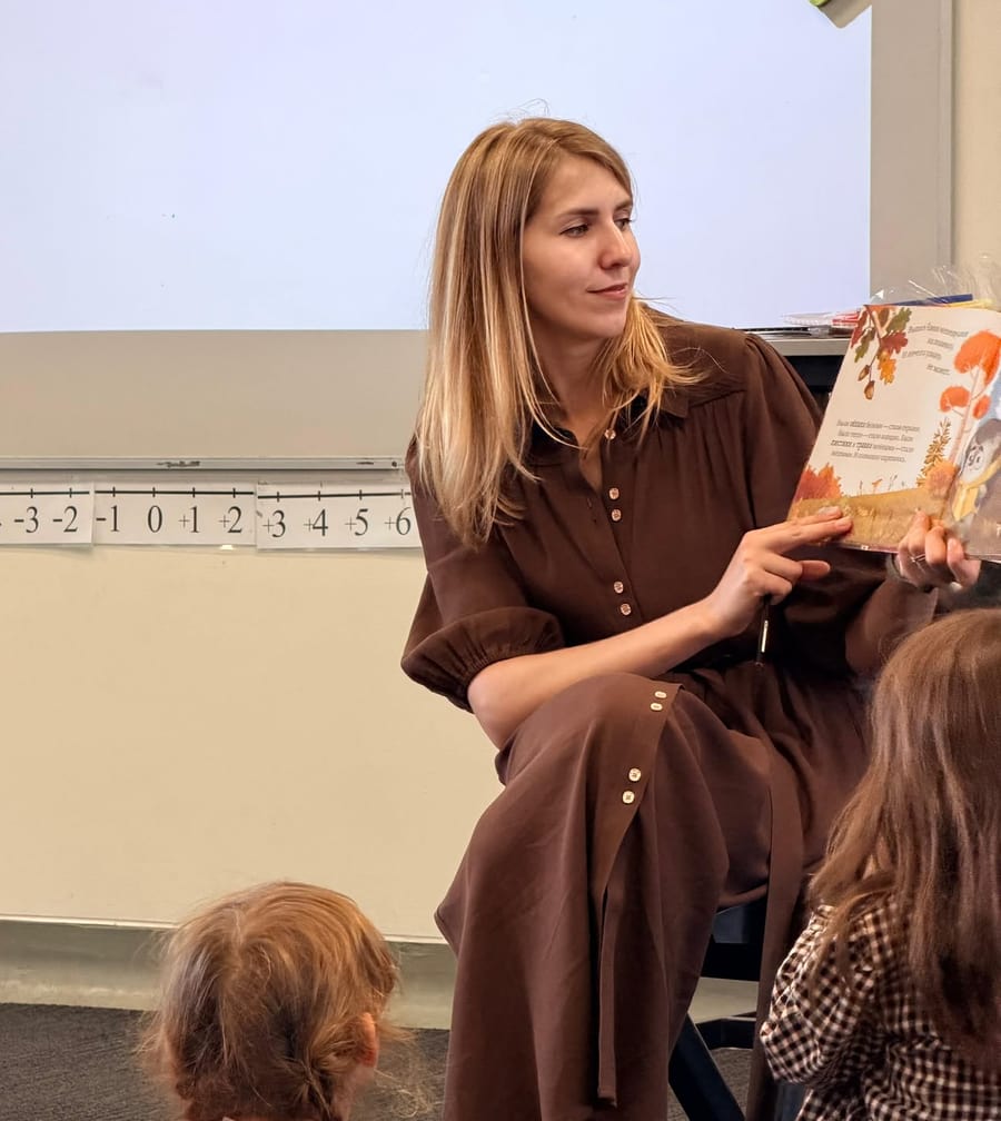 Екатерина читает детям русскую книжку на занятии